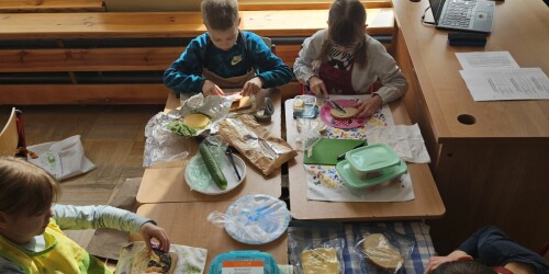 uczniowie układają na talerzach przygotowane kanapki